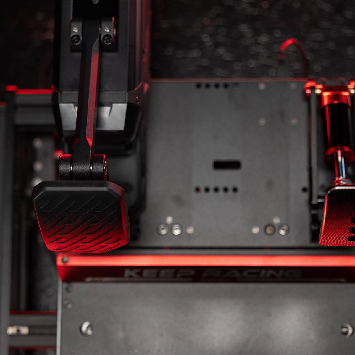 Simagic P-Active pedal face and P1000 baseplate seen from above, installed in a sim racing cockpit
