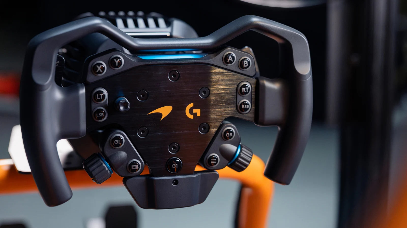 Logitech G RS Formula Wheel McLaren Racing Edition mounted on the RS Wheel Hub, close-up of the papaya McLaren detailing and hub buttons