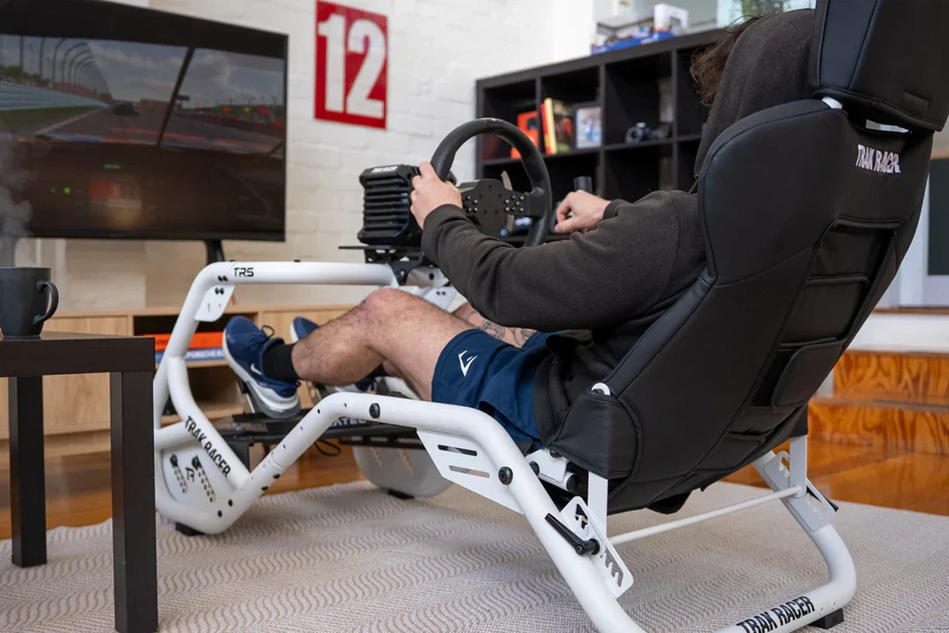 Sim racer driving the Trak Racer TR5 Hybrid Racing Simulator