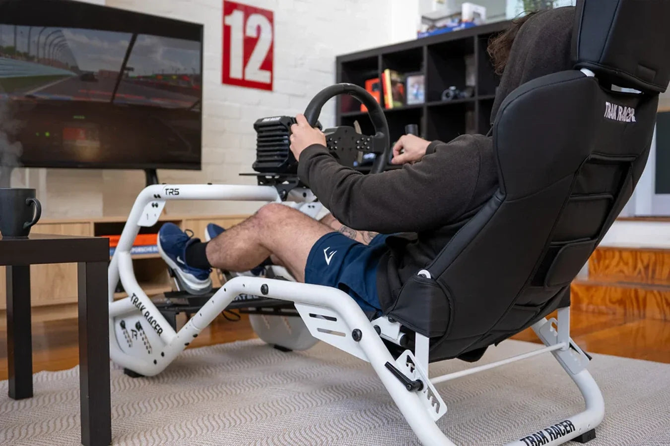 Sim racer driving the Trak Racer TR5 Hybrid Racing Simulator