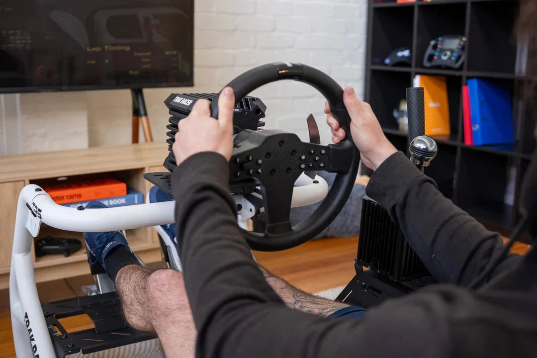 Hands on the wheel in the Trak Racer TR5 Hybrid Racing Simulator cockpit